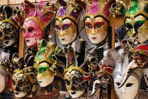 traditionell venetian masker på hyllor i souvenirer affär i Venedig, Italien. skön karneval masker i mängd av färger. äkta och original- venetian fullt ansikte masker för karneval. foto