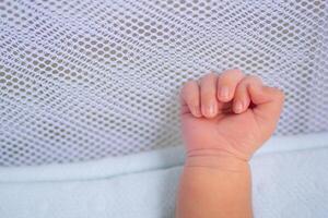 liten hand av nyfödd bebis på en vit filt foto