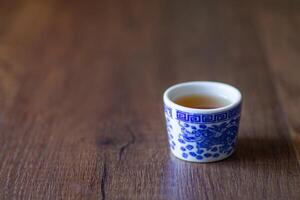 te vatten i en te kopp drake mönster på trä- tabell foto