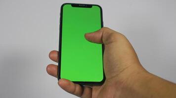hand innehav smart telefon med grön skärm. isolerat på vit bakgrund foto
