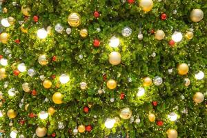 ljus och abstrakt suddig färgrik på jul träd med skimrande glitter, defocused bakgrund foto