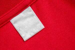 tom vit tvätt vård kläder märka på röd skjorta tyg textur bakgrund foto