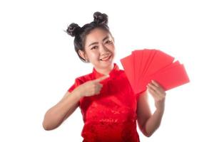 porträtt asiatisk kvinna röd klänning traditionell cheongsam håller röda kuvert på vit bakgrund