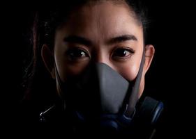 närbild affärskvinna av ung asiatisk kvinna som tar på sig en respirator n95-mask för att skydda mot luftburna luftvägssjukdomar som influensa covid-19 coronavirus pm2.5 damm och smog foto