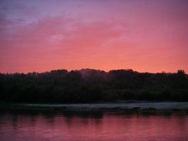 solnedgång ovanför floden i naturligt landsbygdslandskap foto