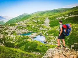 manlig person på klippan njuta av utsikt över bergen foto