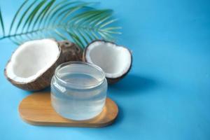 skiva färsk kokosnöt och en flaska olja på ett bord foto