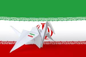 iran flagga avbildad på papper origami kran vinge. handgjort konst begrepp foto