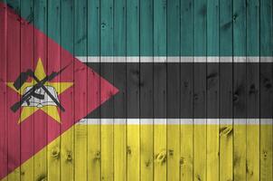 moçambique flagga avbildad i ljus måla färger på gammal trä- vägg. texturerad baner på grov bakgrund foto