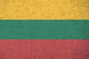 litauen flagga avbildad i ljus måla färger på gammal lättnad putsning vägg. texturerad baner på grov bakgrund foto