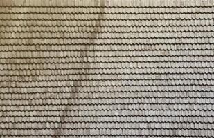 grå trä- tak plattor bakgrund textur. en stänga upp av gammal grå tak täckt med trä- plattor foto
