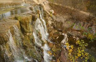 skön vattenfall mellan stor stenar i höst skog. sofievskiy parkera i uman, ukraina foto