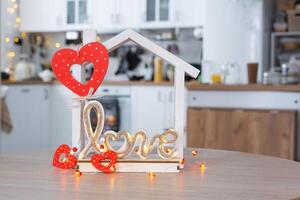 nyckel till mycket liten hus av mysigt Hem med valentine dekor på tabell av kök. gåva för valentines dag, familj kärlek bo. design, projekt, rör på sig till ny hus, inteckning, hyra och inköp verklig egendom foto