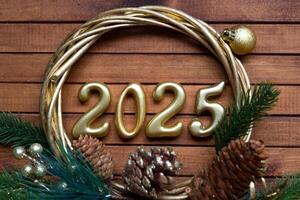Lycklig ny år gyllene tal 2025 på mysigt festlig brun trä- bakgrund med paljetter, snö, lampor av girlanger. hälsningar, vykort. kalender, omslag foto