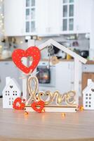 nyckel till mycket liten hus av mysigt Hem med valentine dekor på tabell av kök. gåva för valentines dag, familj kärlek bo. design, projekt, rör på sig till ny hus, inteckning, hyra och inköp verklig egendom foto