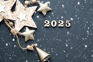Lycklig ny år-trä brev och de tal 2025 på festlig svart bakgrund med paljetter, stjärnor, snö. hälsningar, vykort. kalender, omslag foto