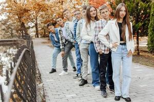 vänskap, rörelse, handling, frihet och människor begrepp - grupp av Lycklig tonåringar eller skola vänner Framställ och har roligt utomhus mot natur eller skog bakgrund. foto