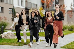 grupp av många Lycklig tonåringar klädd i tillfällig kläder har roligt och har roligt nära högskola. begrepp av vänskap, stunder av lycka. skola vänskap foto