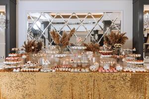 godis bar för en bröllop. godis bar stående festlig tabell med desserter, muffins och macarons. skön och gott. foto
