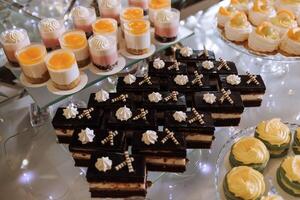 en utsökt bröllop. cupcakes, kakor. godis bar för en bankett. firande begrepp. modern desserter. tabell med sötsaker, godis. frukt foto