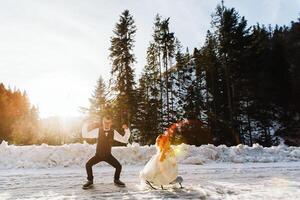 de brud och brudgum rida en släde på en snöig väg i vinter. vinter- bröllop på de gata i de skog. de vinter- högtider. Lycklig par sledding i snöig vinter- väder foto