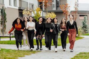 grupp av många Lycklig tonåringar klädd i tillfällig kläder har roligt och har roligt nära högskola. begrepp av vänskap, stunder av lycka. skola vänskap foto