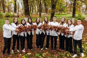 vänskap, rörelse, handling, frihet och människor begrepp - grupp av Lycklig tonåringar eller skola vänner Framställ och har roligt utomhus mot natur eller skog bakgrund. foto