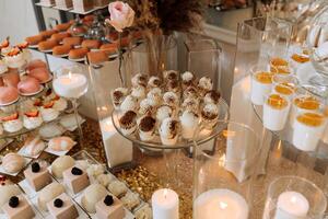godis bar för en bröllop. godis bar stående festlig tabell med desserter, muffins och macarons. skön och gott. foto
