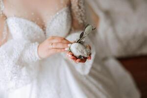 bröllop boutonniere av blommor i de händer av de brud. bröllop detaljer. de först möte av de brud och brudgum. de brud är väntar för de brudgum. foto