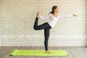latinsk kvinna utövar yoga på mattan foto