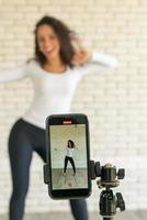 latinsk kvinna skapade sin dansvideo med smartphonekamera. för att dela video till sociala medier-applikationer.