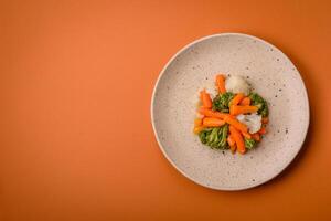 utsökt färsk grönsaker broccoli, blomkål, morötter ångad med salt och kryddor foto