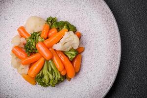 utsökt färsk grönsaker broccoli, blomkål, morötter ångad med salt och kryddor foto