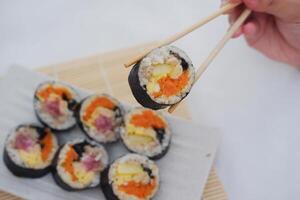 sushi rullar på en tallrik på en vit bakgrund. japansk mat foto