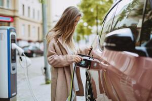 ai genererad kvinna använder sig av ev bil laddning station för avgift ev batteri. plugg för fordon med elektrisk motor. rena energi. laddning punkt på bil parkering massa. framtida transport teknologi modern bil. foto