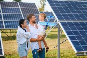 Lycklig familj nära sol- paneler. alternativ energi källa foto