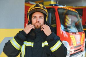 porträtt av manlig brandman i enhetlig på brand station foto