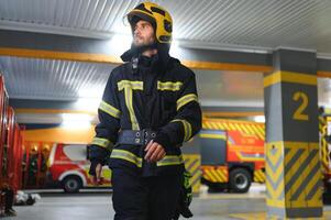 porträtt av manlig brandman i enhetlig på brand station foto