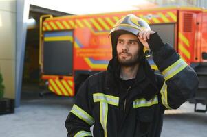 porträtt av manlig brandman i enhetlig på brand station foto