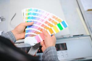 skriva ut hus arbetstagare kontrollerande utskrift bearbeta kvalitet och kontroll färger med förstorande glas foto