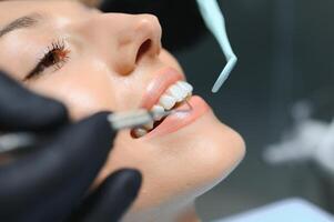 läkare granskning patientens tänder, närbild. kosmetisk tandvård foto