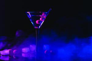 dryck martini. Martini med oliver på en svart tabell. fri Plats för text. foto