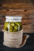 inlagd gurkor i de burk. Ingredienser för betning gurkor. gurkor, dill, vitlök. glas burkar med ättiksgurka foto