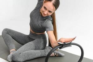 sexig ung kvinna håller på med övning på isolerat vit bakgrund foto