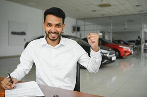 Lycklig indisk man köpa ny biodiesel eco bil i lux showroom. foto