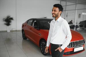 en ung indisk man väljer en ny bil på en bil återförsäljare foto