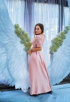 en kvinna stående i främre av ett ängel vingar bakgrund foto