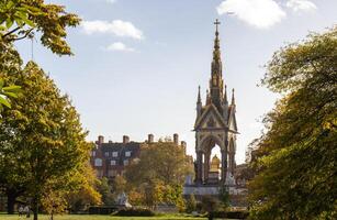 de albert minnesmärke i kensington trädgårdar, london, inramade förbi gyllene höst lövverk - en hyllning till victorian påhittighet foto