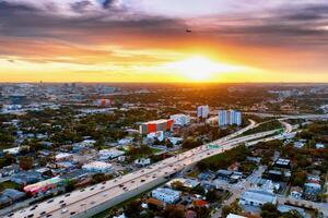 antenn se av miami stad på majestätisk solnedgång. fånga de hisnande skönhet av miamis stadsbild från ovan som de Sol målarfärger de himmel i vibrerande nyanser under solnedgång. foto