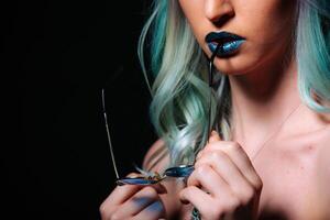 vibrerande kvinna med blå hår innehav sax foto